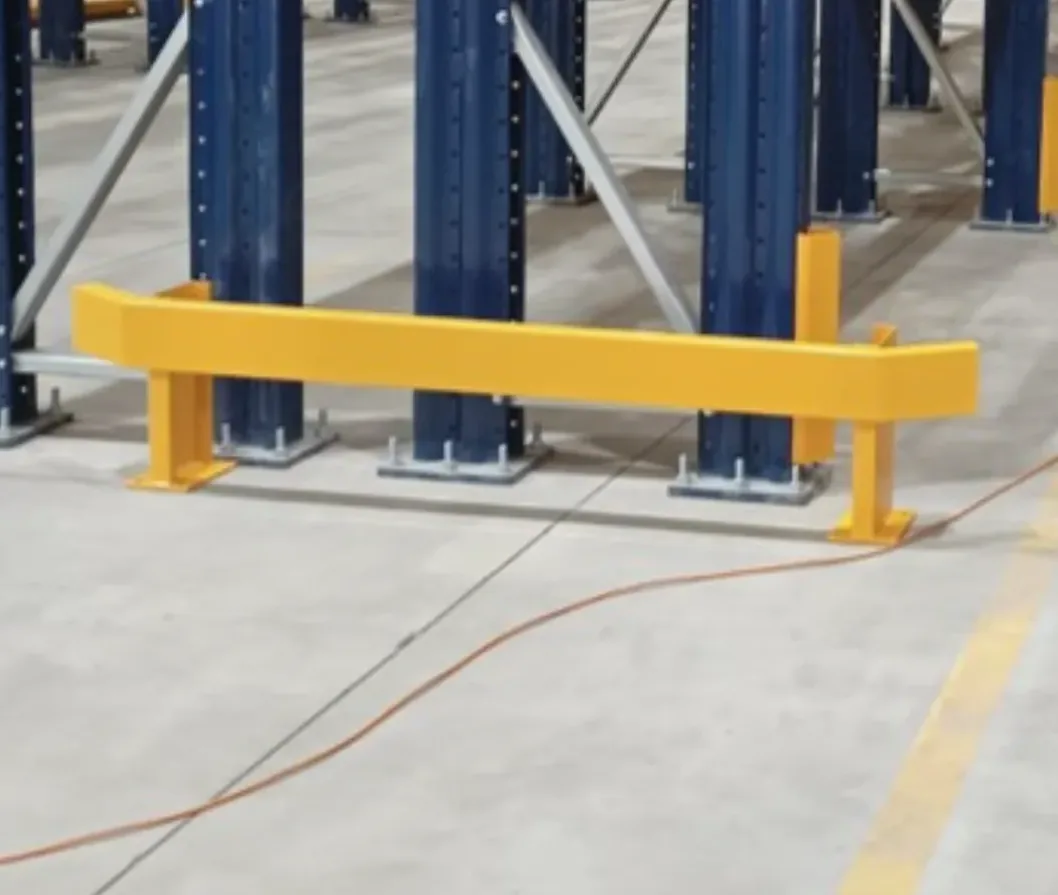 Resguardo de viga y barrera de protección amarilla frente a un rack con montantes azules
